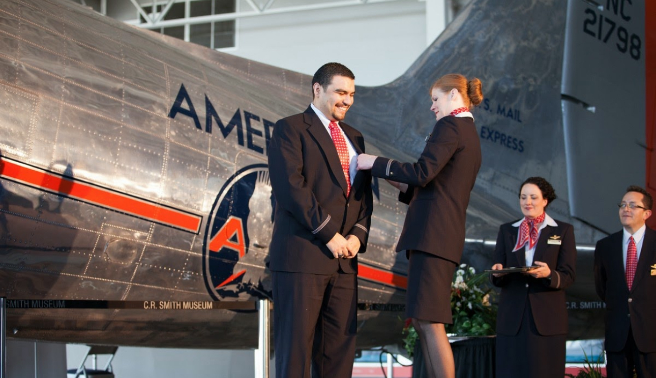 Flight Attendant Graduation Ceremony where Angel is getting his wings pinned by his flight trainer. 
